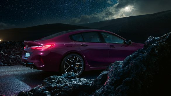 BMW 8er Gran Coupé M von rechts bei Nacht auf der Straße mit Felsen