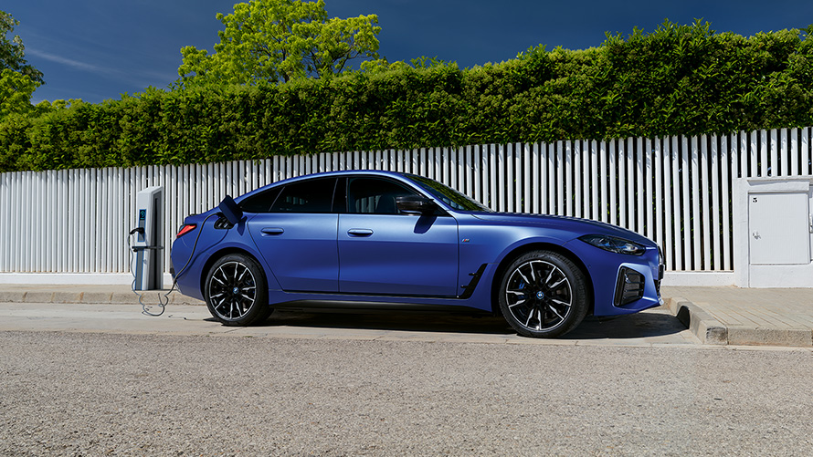 BMW i4 M50 G26 2021 BMW Individual Frozen Portimao Blau metallic Seitenansicht angeschlossen an Ladesäule