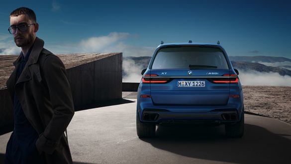 BMW X7 M60i xDrive G07 LCI Frozen Marina Bay Blue Heckansicht stehend vor Berglandschaft