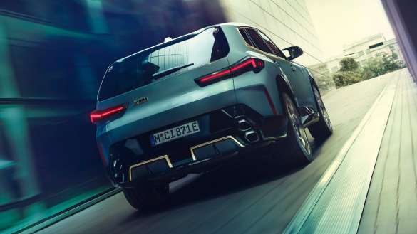 BMW XM G09 Heckansicht fahrend in urbaner Umgebung